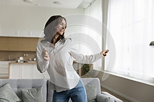 Untroubled woman dancing in cozy studio apartment