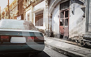 Unusable car with old building