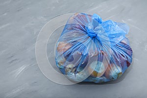 Unused fruits and vegetables. Rotten organic food waste in biodegradable plastic bag on gray background. Homemade composting