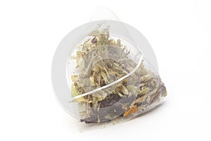 Unused pyramid tea bag with a tag on a white background, top view. Place for text