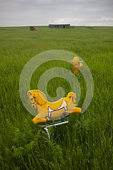 Unused rocking-horses in a vast North Dakota landscape