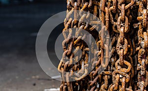 Unused and rusty snow chains hanging from a wall