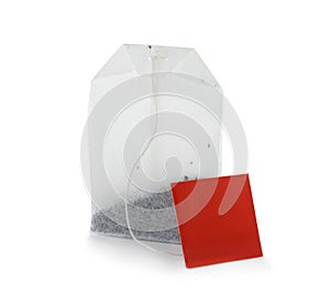 Unused tea bag with tag on white background.