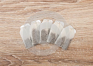 Unused teabags in a row on wooden background