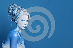 Unusual cool cold woman with blue and white body art, carnival makeup and hairstyle