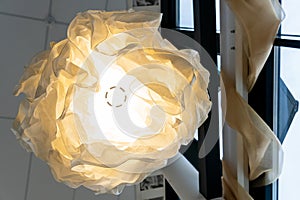 An unusual designer chandelier made of multicolored paper made by hand. Large paper lamps in a modern style. cozy interior in the