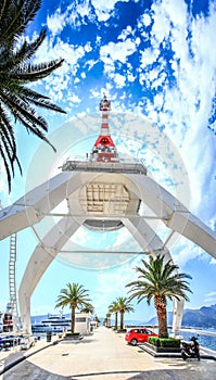 Unusual foreshortening of the snow-white port crane against the background of a bright blue sky.