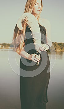 Unusual gothic girl with long red hair and feather