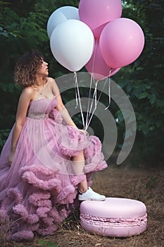 Unusual hipster woman holds air balloons at her party at the night