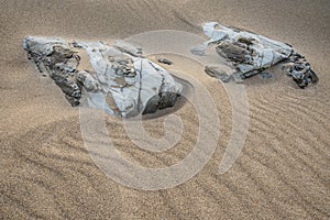 Unusual landscape image giving an abstract look of small scale rocks in beach as large cliffs and plains with lovely sand texture