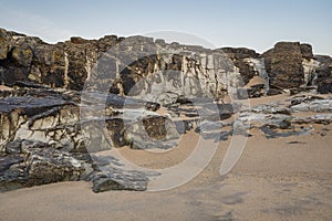 Unusual landscape image giving an abstract look of small scale rocks in beach as large cliffs and plains with lovely sand texture