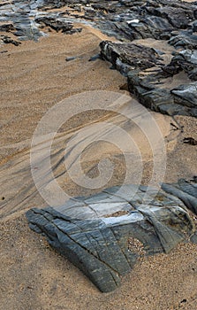 Unusual landscape image giving an abstract look of small scale rocks in beach as large cliffs and plains with lovely sand texture