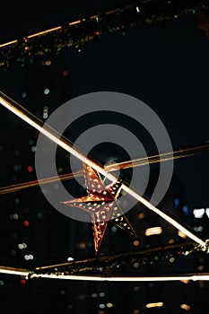 an unusual looking star in the sky at night time, with lights and buildings in