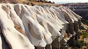 Unusual Mountains landscape in Cappadocia Turkey, Birds eye view 4k aerial drone. Red and Pink Rocks, Dramatic