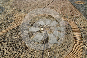 Unusual pavement with creative pattern from metal details, sea pebbles, bricks; ceramic, granite