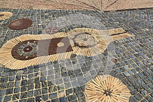 Unusual pavement with creative pattern from rusty metal details, ceramics, cobbles and red bricks