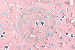 An unusual picture with scattered stationery. Funny faces with puppet eyes. Clips, clerical buttons and asterisks in