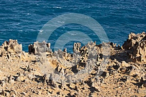 Unusual rock structure against the sea water background, interesting geological object