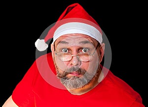 Unusual Santa Claus isolated on black background. Surprised Santa Claus looks at us. Middle-aged man as Santa Claus