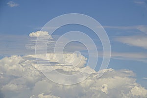 Unusual sky - billowing white clouds in blue teal sky with horizontal grey whispy almost transparent  clouds in foreground