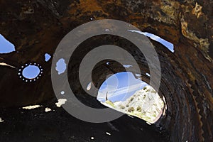 Unusual view from inside a discarded boiler drum on the Victorian brickworks site at Porth Wen, Isle of Anglesey, North Wales
