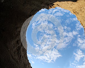 unusual view from inside a hole dug in the sand from which you c