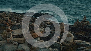 Unusual volcanic rock formations and a sea waves viewed from a cliff.