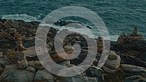 Unusual volcanic rock formations and a sea waves viewed from a cliff.