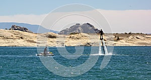 A man standing on jets of water at a reservoir in the desert