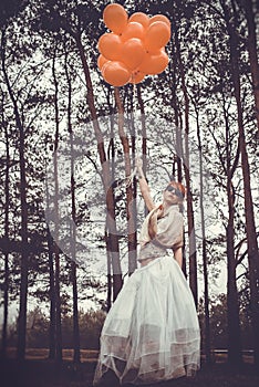 Unusual woman with balloons as concept outdoors