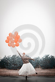 Unusual woman with balloons as concept outdoors