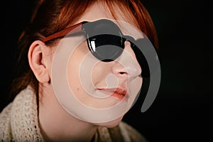 Unusual woman studio with red hair and sunglasses