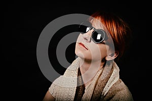 Unusual woman studio with red hair and sunglasses