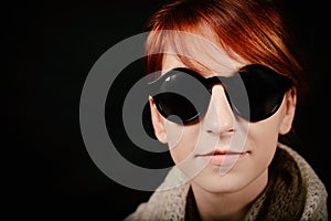 Unusual woman studio with red hair and sunglasses