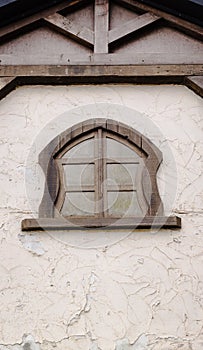 An unusual wooden window in the wall of the house.