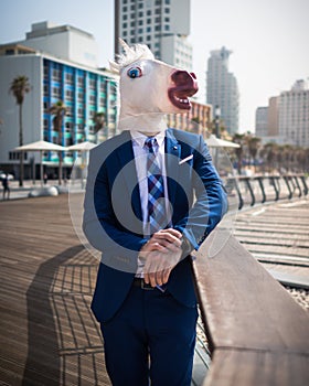 Unusual young man in elegant suit stands on the city waterfront