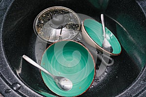 Unwashed dirty dishes in the kitchen sink, hand washing kitchen utensils, household chores and routine concept