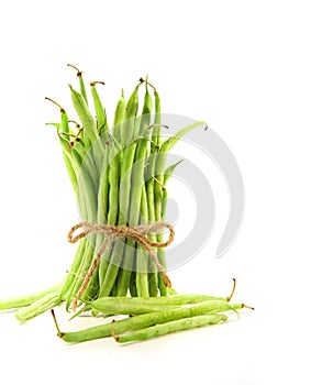Unwashed green beans tied with cord on white