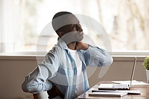 Unwell african American male suffer from neck pain photo