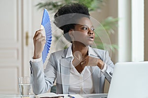 Unwell african businesswoman office worker suffer heatstroke at workplace without air conditioner