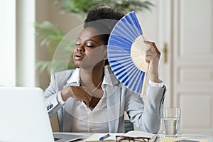 Unwell african businesswoman office worker suffer heatstroke at workplace without air conditioner