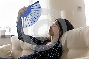 Unwell Asian girl feel overheated wave using hand fan