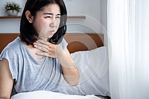 Asian woman suffering from nausea in bed. food poisoning or pregnancy concept photo
