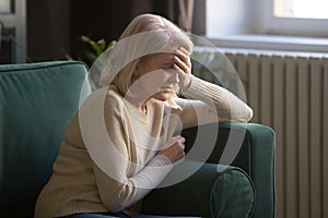 Unwell elderly woman feel sick suffering from headache photo