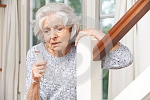 Unwell Senior Woman Using Personal Alarm At Home