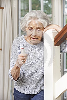 Unwell Senior Woman Using Personal Alarm At Home photo