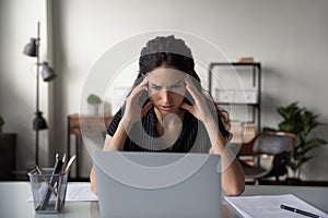 Unwell woman suffer from headache working on computer