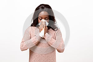 Unwell young woman blowing her nose