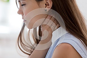 Unwell young woman touch neck suffering from angina