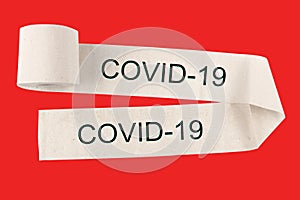 Unwound roll of toilet paper with the inscription COVID-19 , on a red background. The concept of warning and deficit.